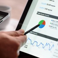 负责合规与来源核查的同事在电脑前比对公开页面截图，桌上放着标注过的打印材料
